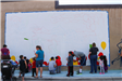 People Stand in Front of Outlined Mural